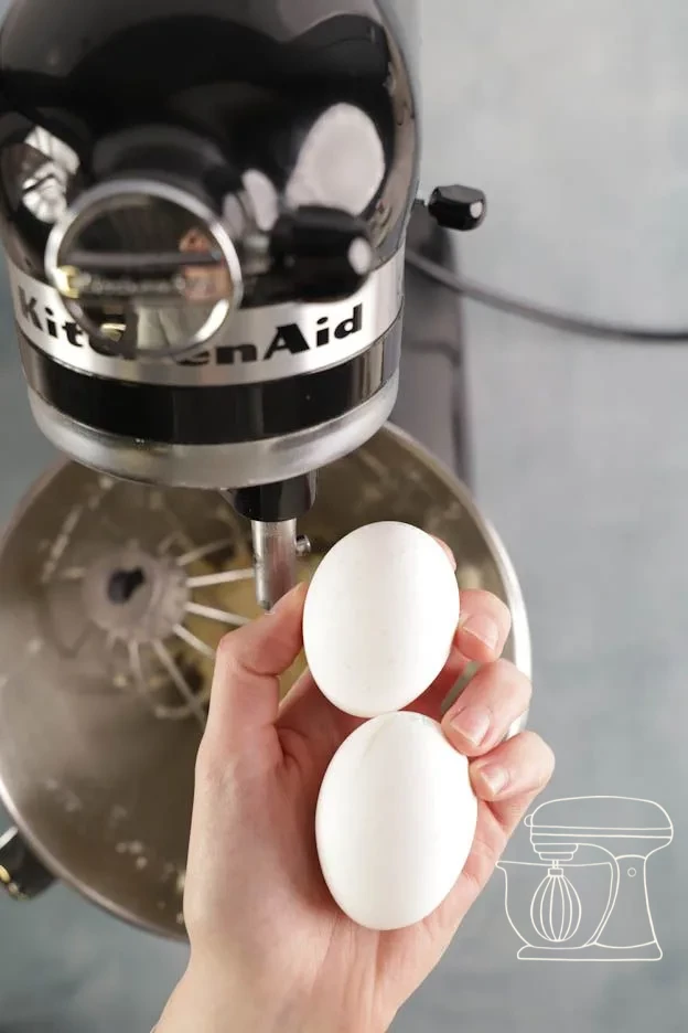 A pinch of salt added to the butter-sugar mixture · Two whole eggs added to the batter · Smooth mixture after beating in the eggs