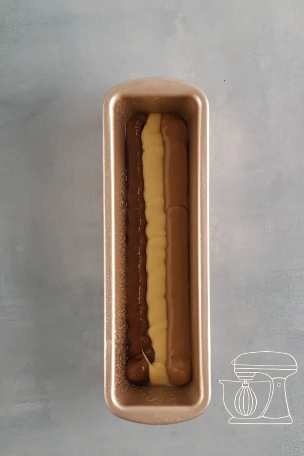 Three batter colours piped alternately into the cake tin · Cake tin filled with alternating batter stripes