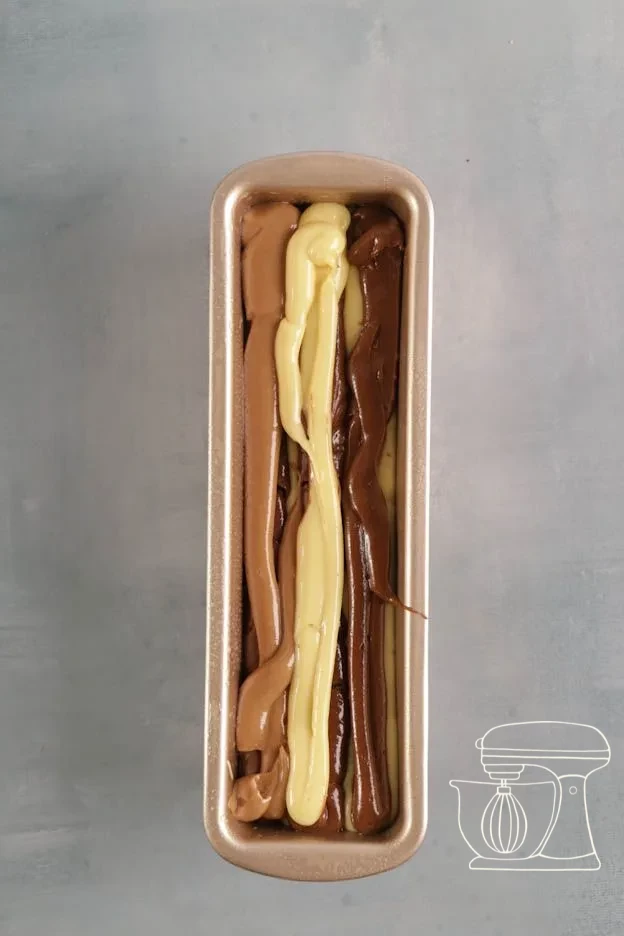 Three batter colours piped alternately into the cake tin