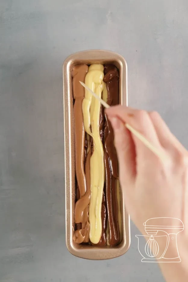 Three batter colours piped alternately into the cake tin