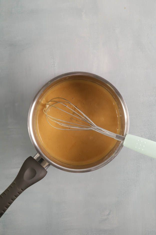 Mixing bowl containing two egg yolks with sugar