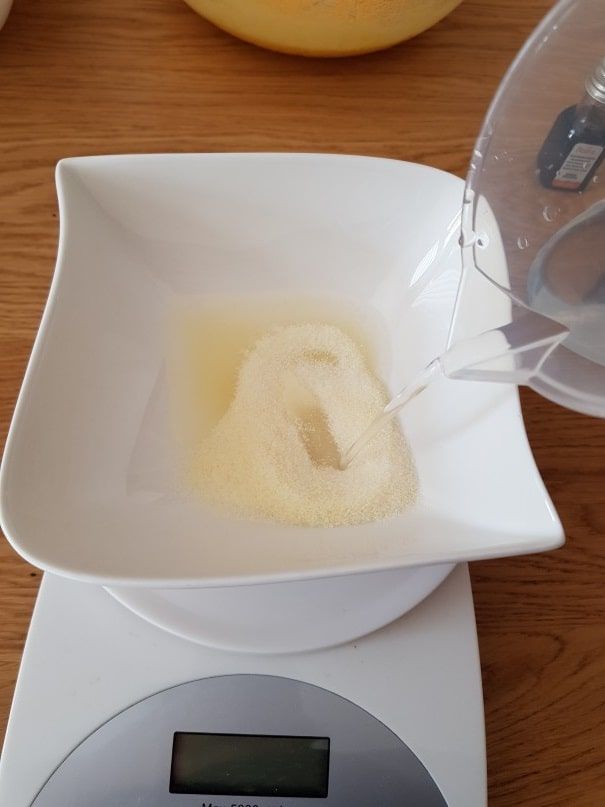 Liquid ingredient weighed in a white dish on the digital kitchen scale for the mille-feuille