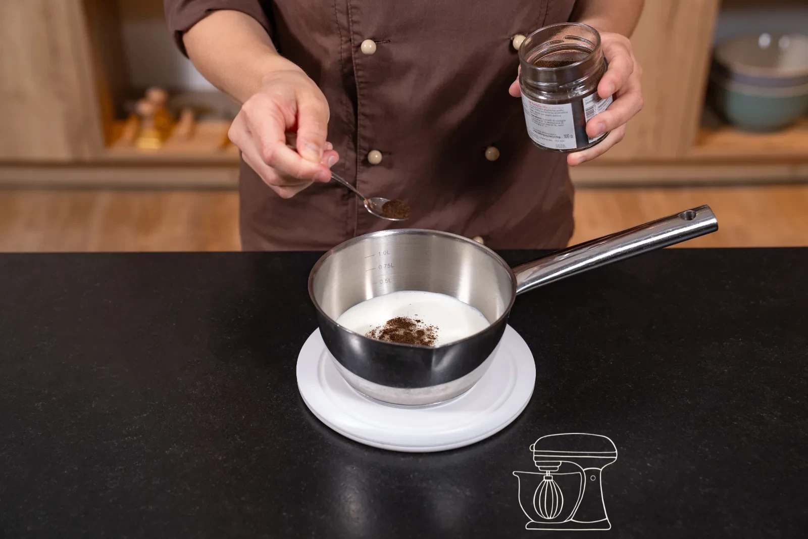 Thickened vanilla cream being stirred in the pot with a whisk, with a bowl and cling film beside it