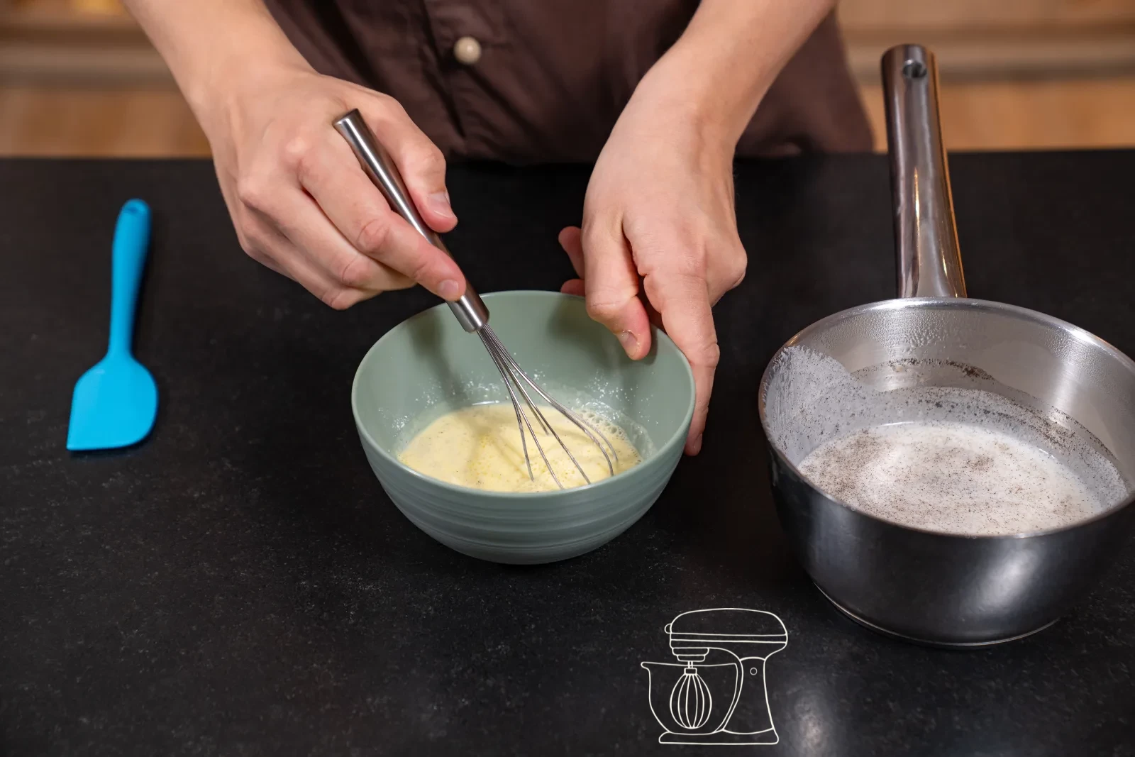 Thickened vanilla cream being stirred in the pot with a whisk, with a bowl and cling film beside it