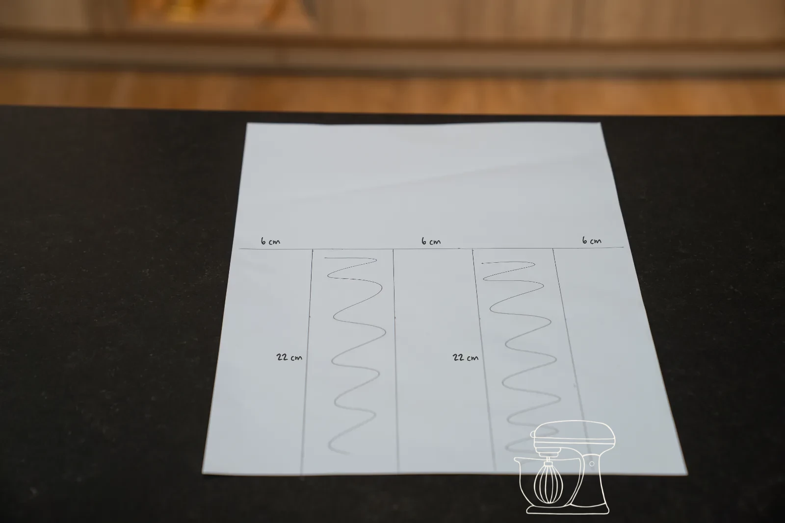 Rectangles of 22 by 6 centimetres drawn on an A3 sheet, with a sheet of baking paper over it on the tray