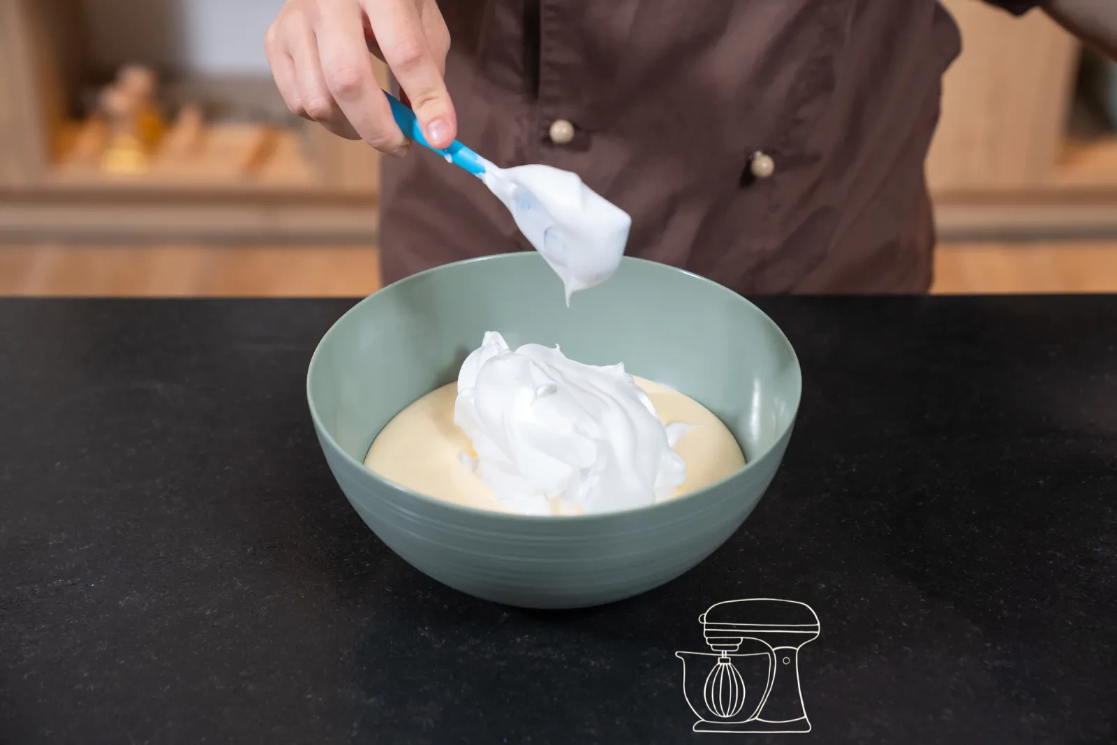 Pale egg-yolk-and-sugar foam in a bowl, with glossy whipped egg white and a sieve of flour beside it