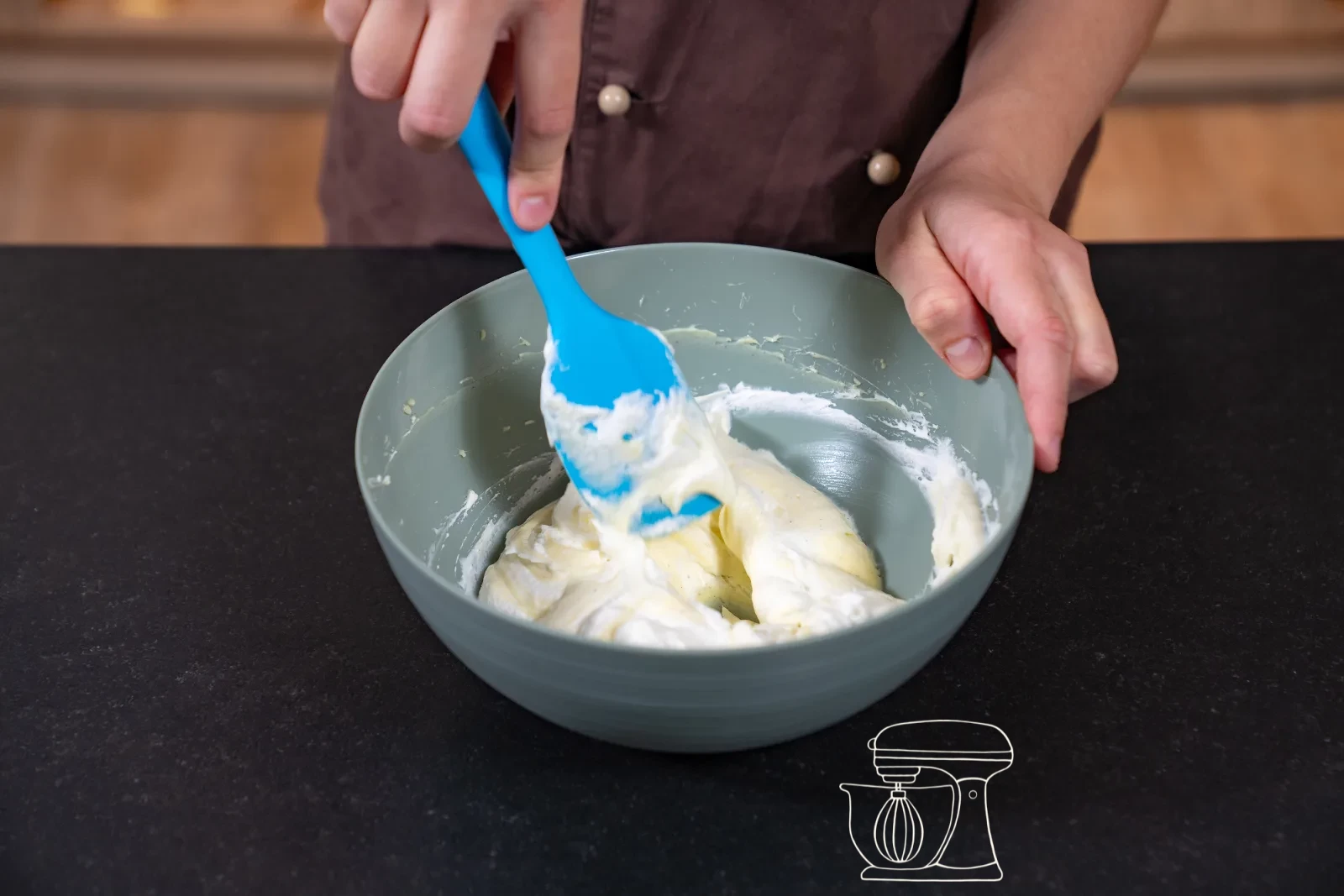 Thickened vanilla cream being stirred in the pot with a whisk, with a bowl and cling film beside it