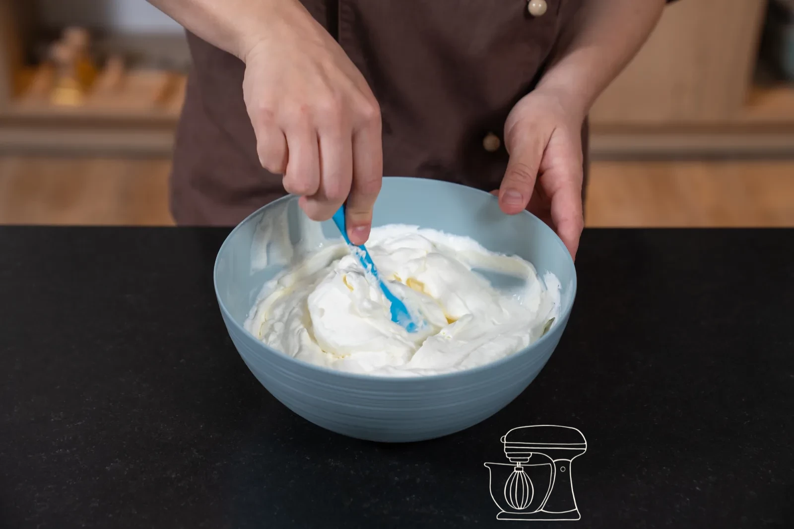 Creamy quark mixture in a bowl, a dough scraper folding in whipped cream in three portions