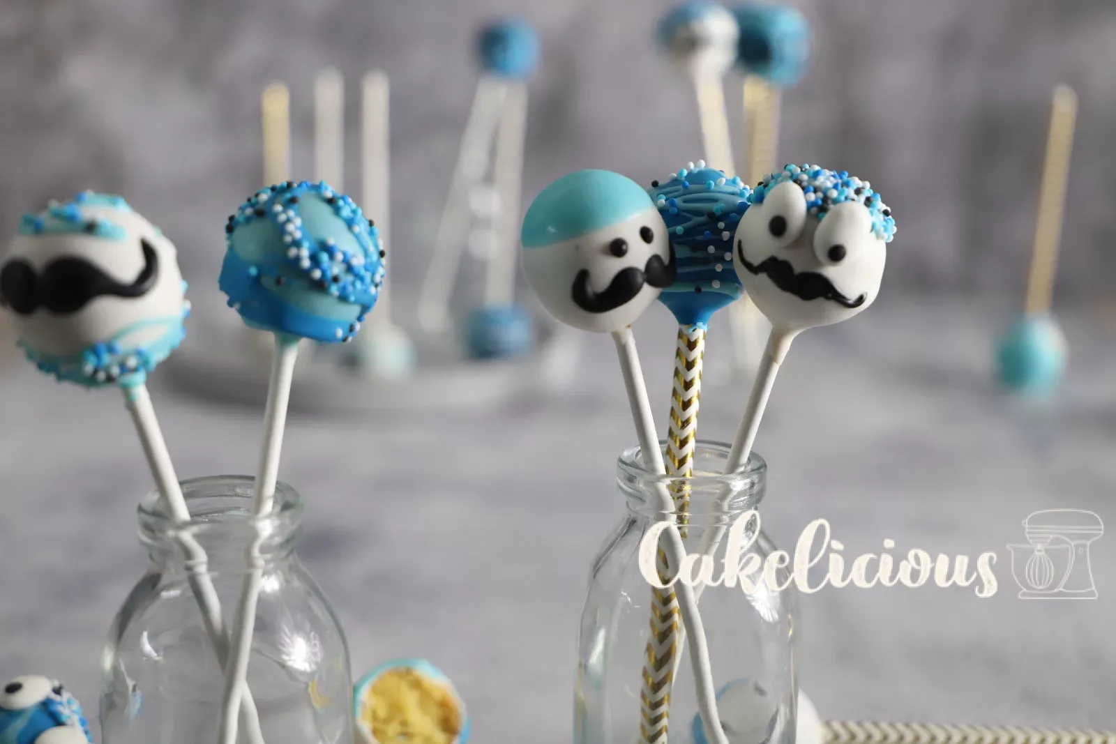 Blau-weisse Cake Pops mit Gesichtern in Glasflaschen