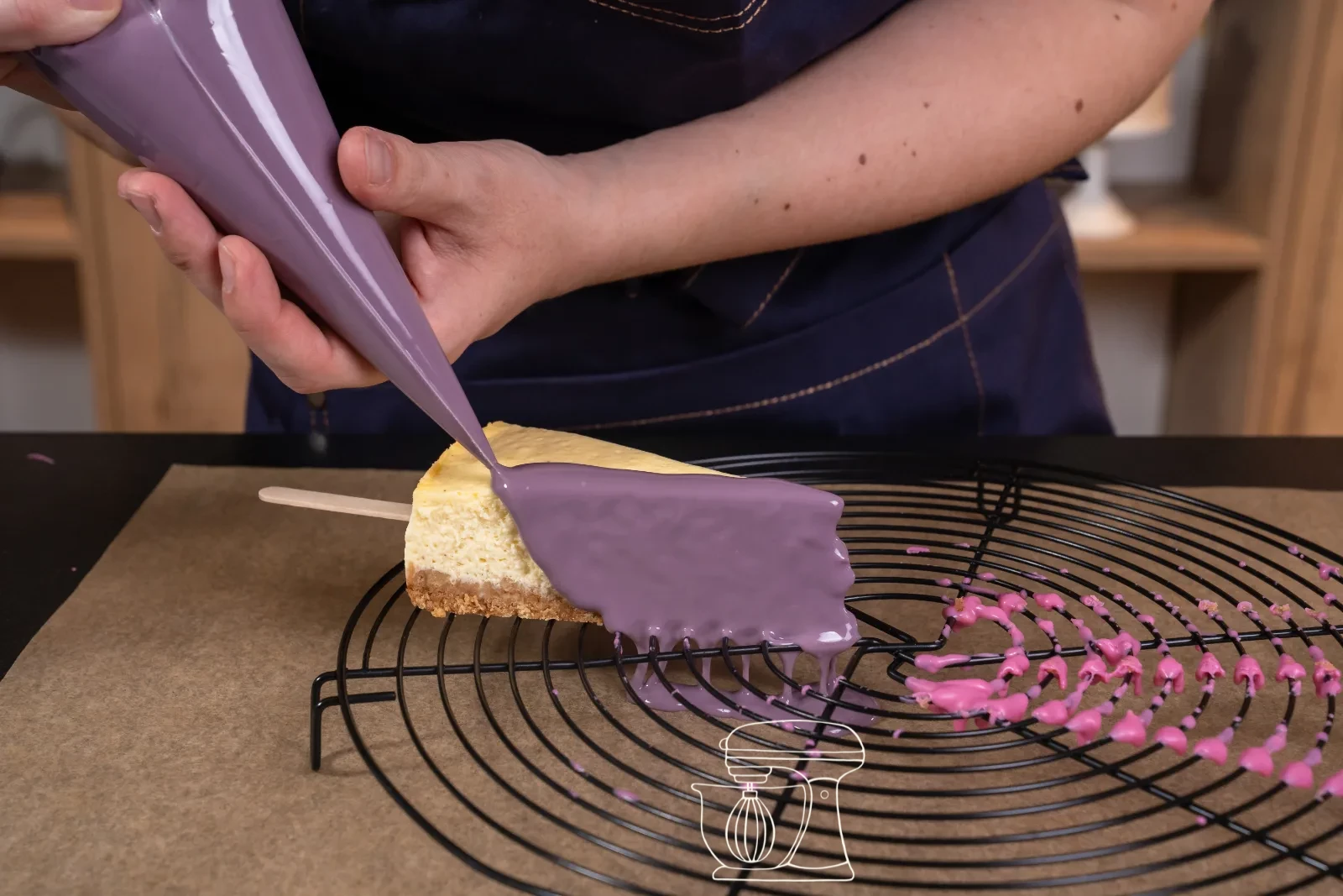 La glassa viola viene versata su un pezzo di cheesecake sulla griglia da pasticceria
