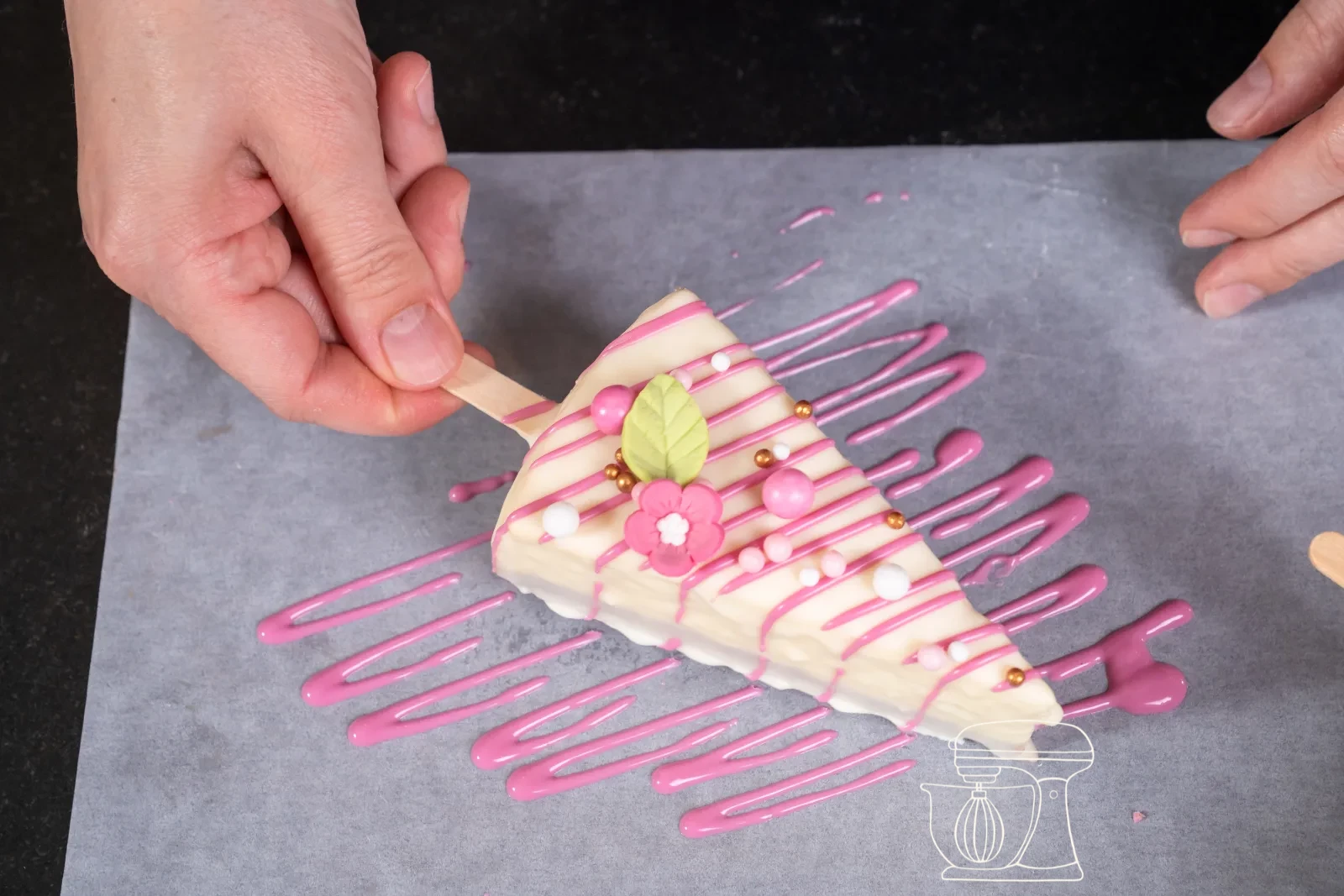 Linee rosa sottili vengono tracciate su un pezzo glassato di bianco