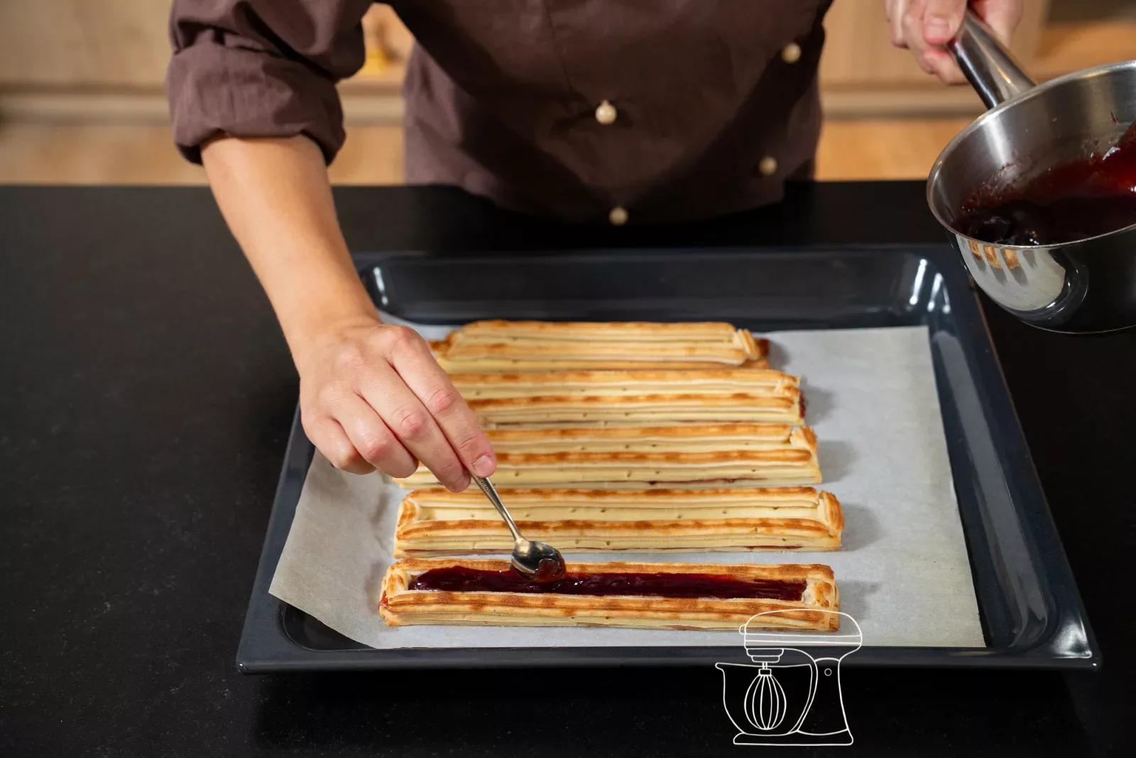 Hot raspberry jam being spooned between the almond rails