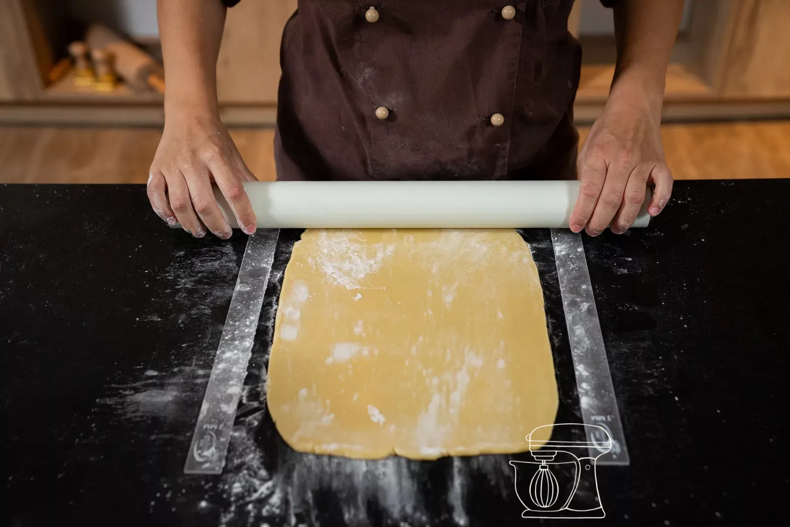 Shortcrust pastry is rolled out into a rectangle between two rolling guides
