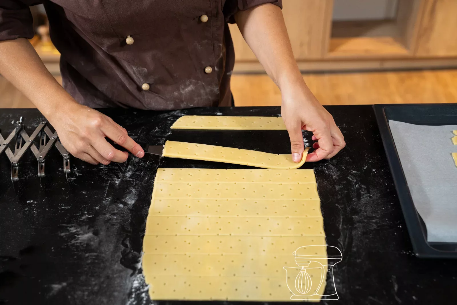 A cut strip of dough is lifted off the work surface
