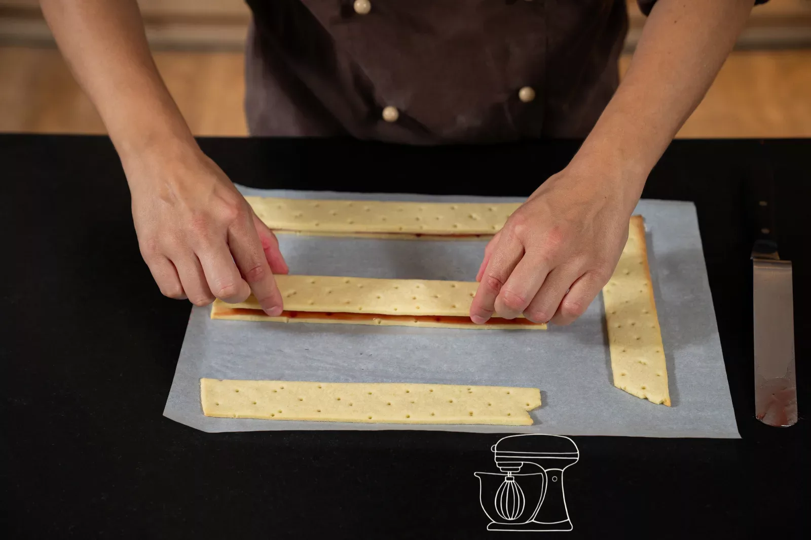 Second shortcrust pastry strip being placed on the coated strip