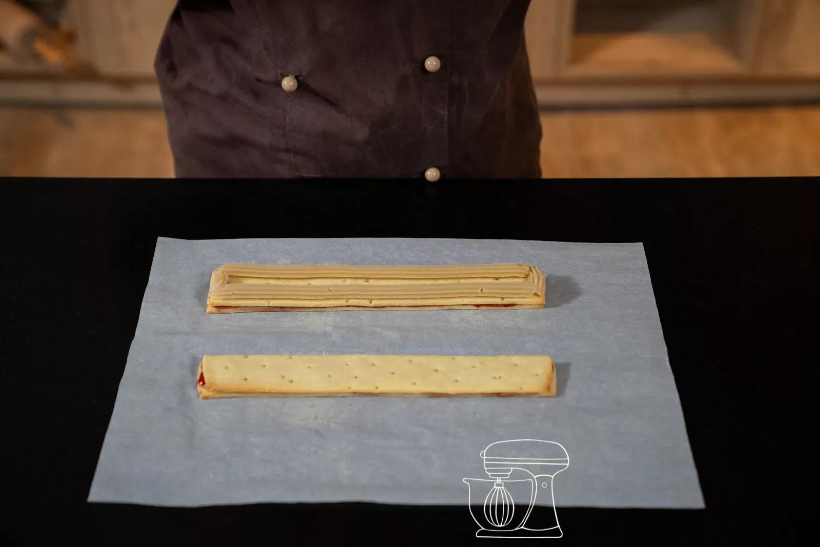 Two dough strips each with two strips of almond paste on baking paper