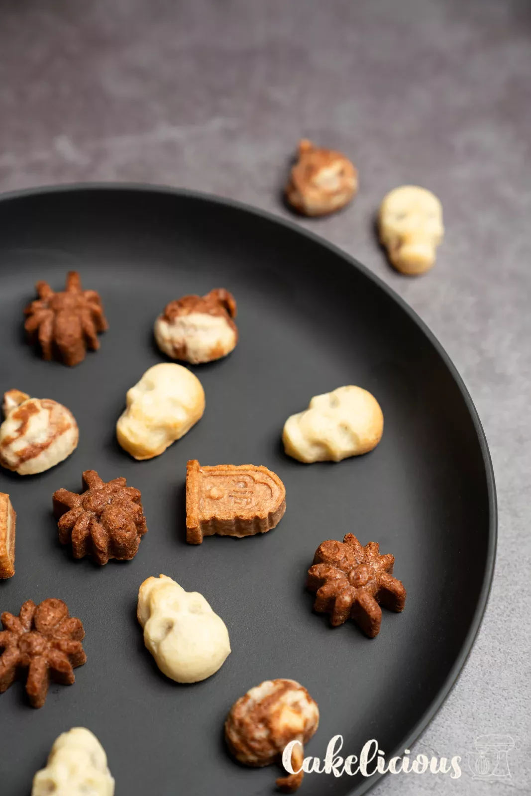 Light, dark and marbled Halloween biscuits on a black plate