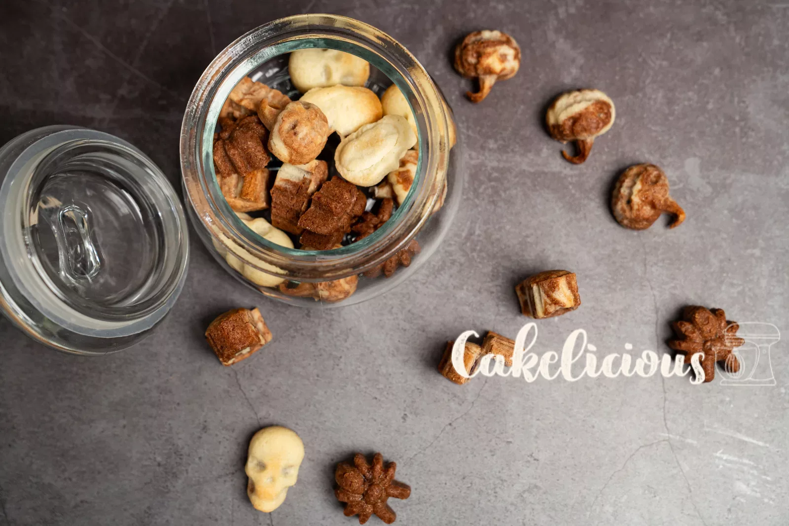 Open jar with filled Halloween biscuits seen from above