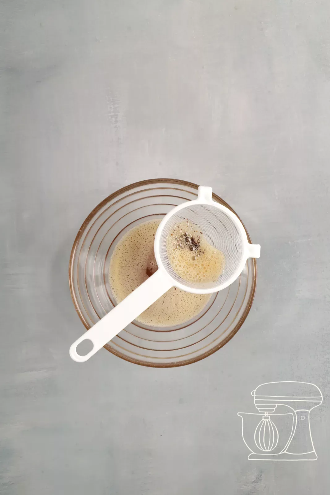 Browned butter being filtered through a fine sieve