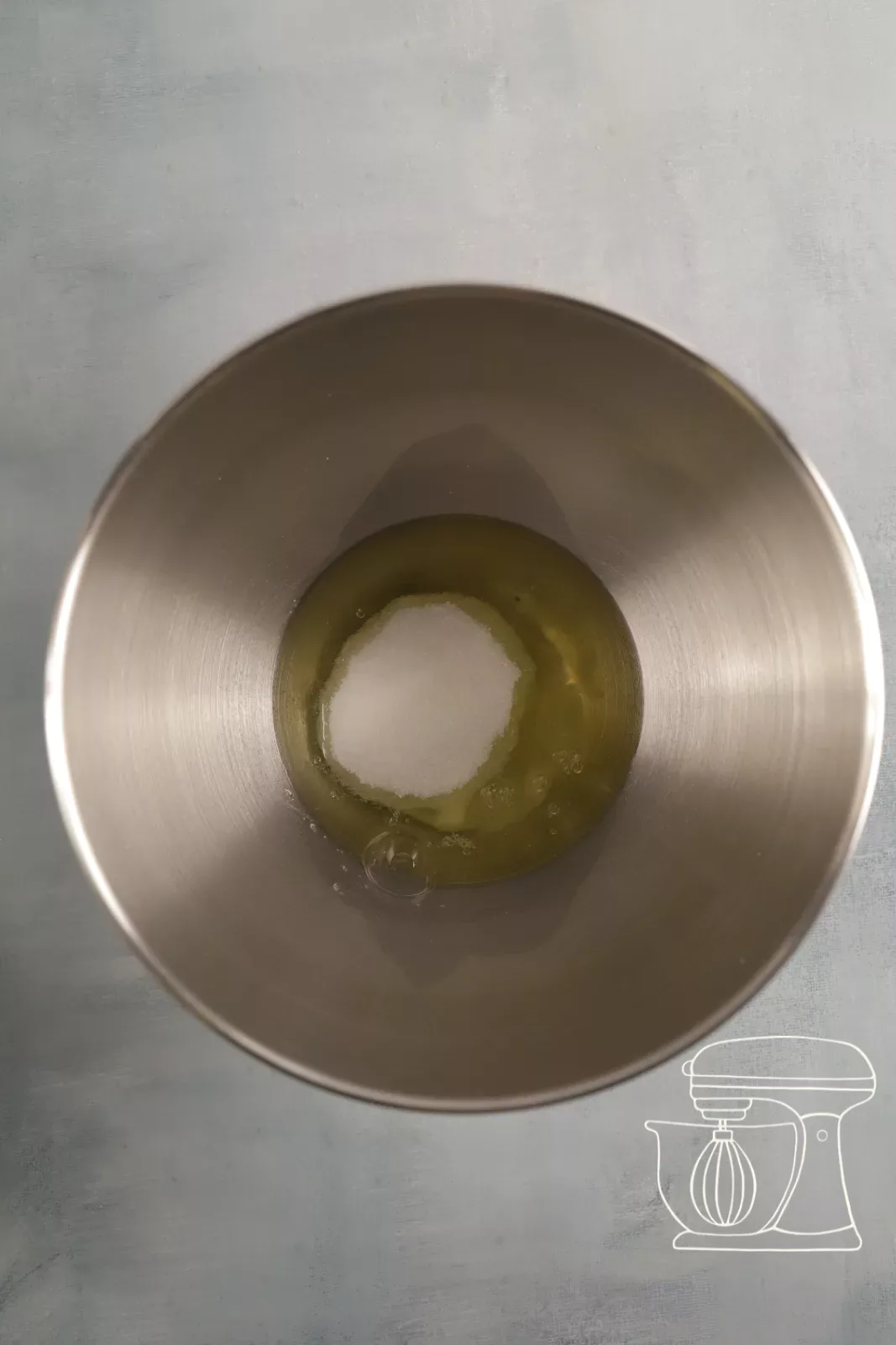 Egg white and sugar in the mixing bowl of the stand mixer