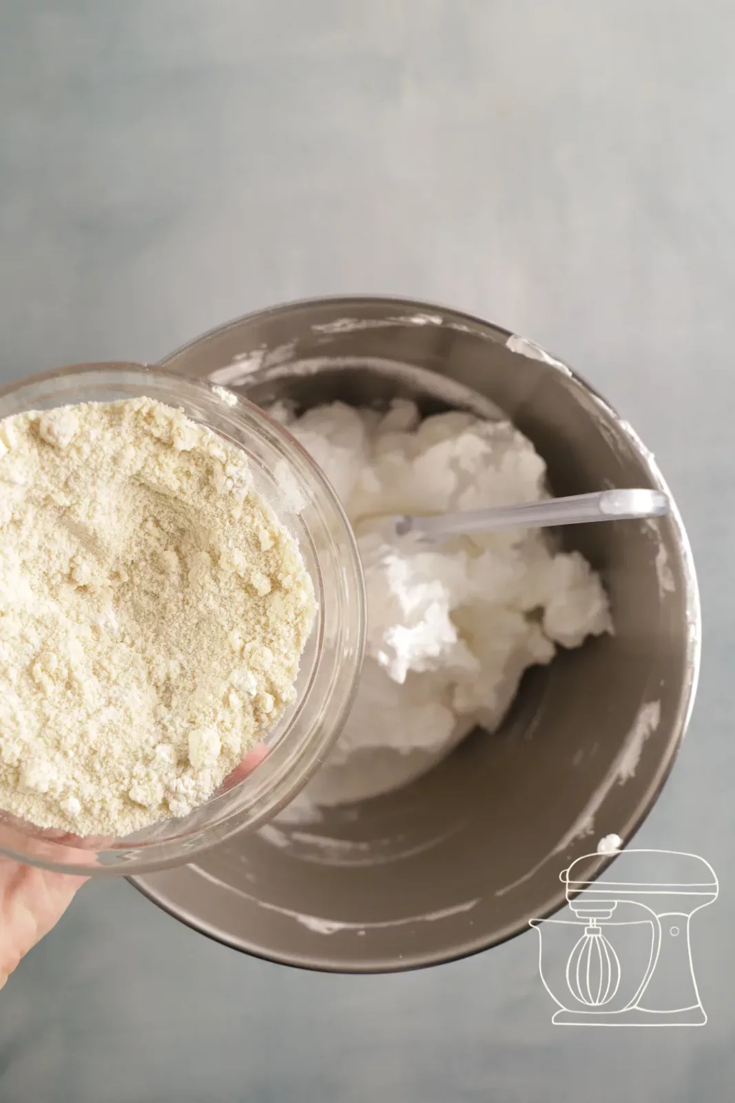 Flour and almond mixture being added to the firm meringue