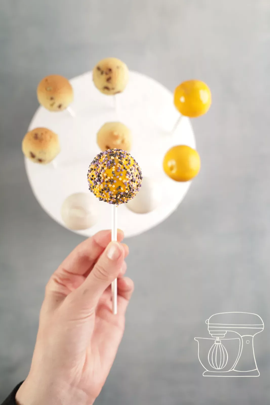 Cake pop being dipped into white Deco melts