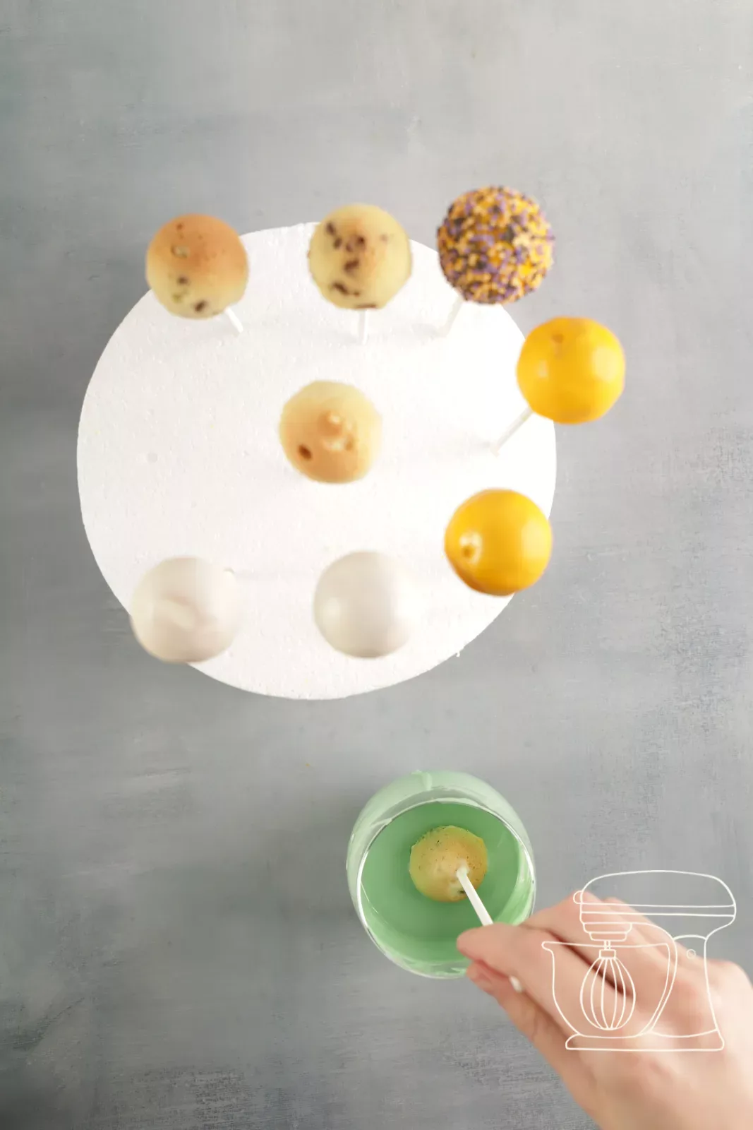 Cake pop being sprinkled with Halloween mini pearls
