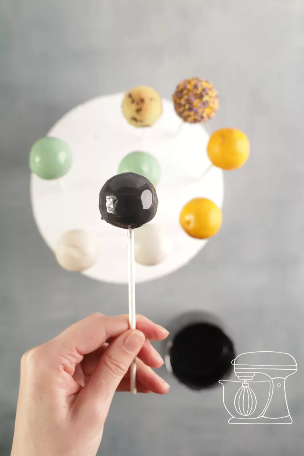 Halloween cake pops in white, orange, green and black in the Styrofoam