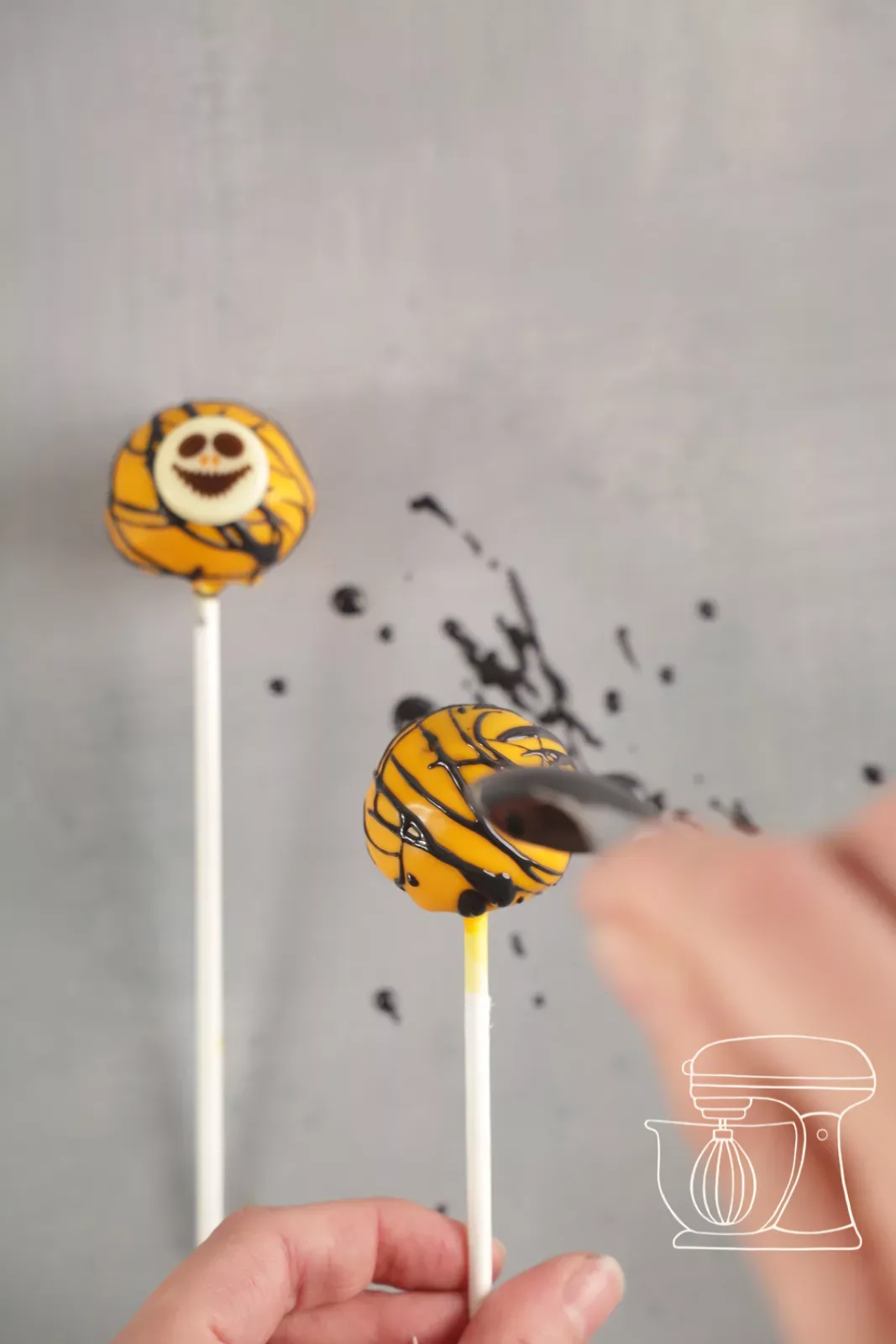 Orange pumpkin cake pop with white Halloween chocolate decorations