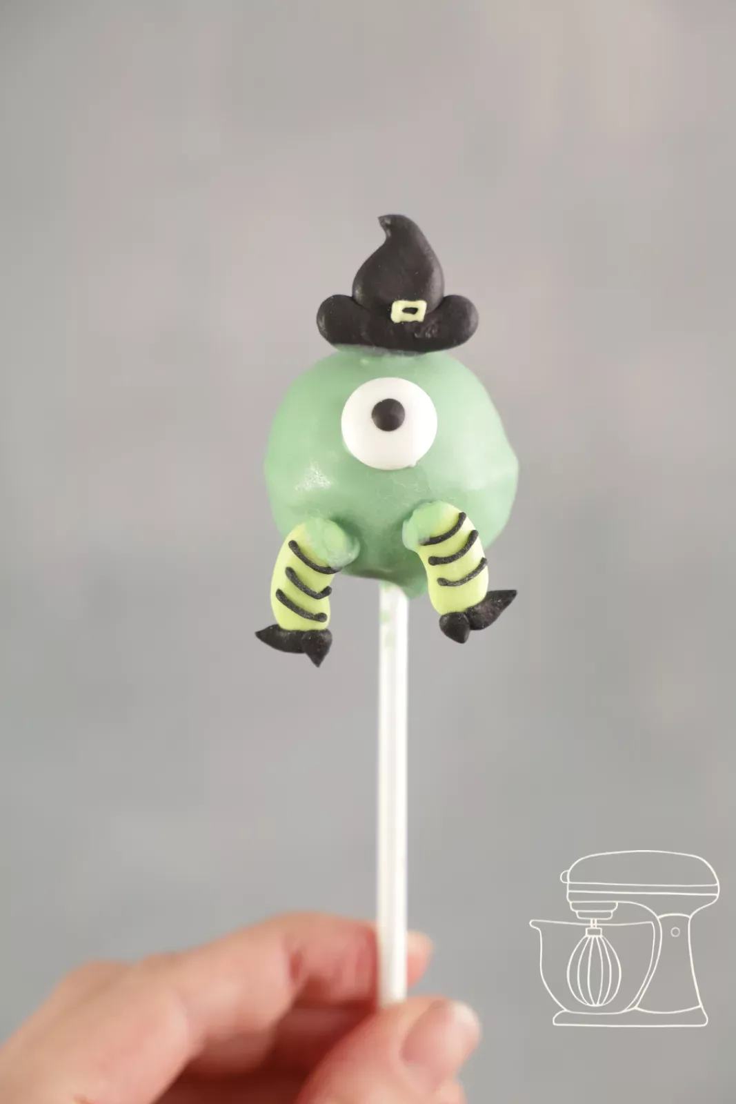 Finished monster cake pop with candy eye, feet and witch's hat