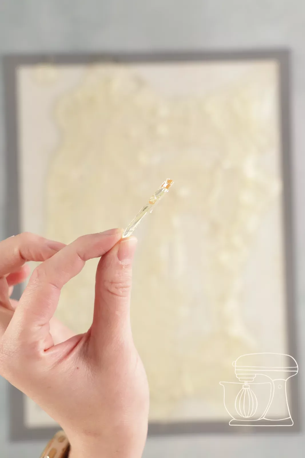 Isomalt wird mit einem kleinen Ausrollstab in Splitter zerbrochen