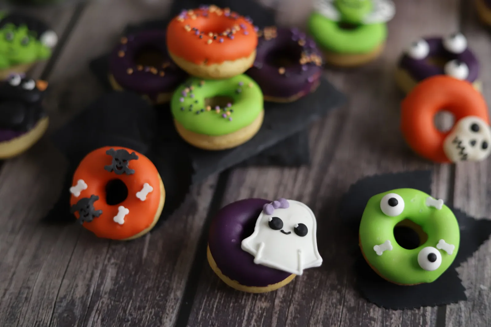 Mini-beignets d'Halloween glacés en couleurs avec décoration d'yeux en sucre et vermicelles