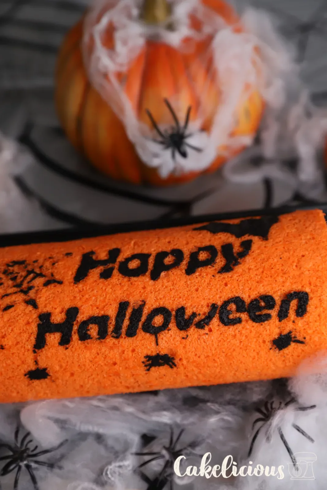 Halloween chocolate roulade with orange sponge and black bat motifs