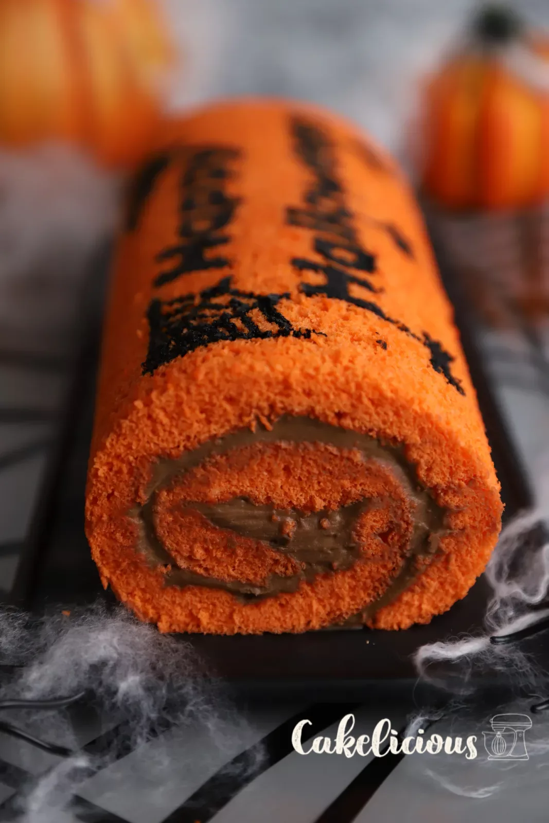 Halloween chocolate roulade with orange sponge and black bat motifs
