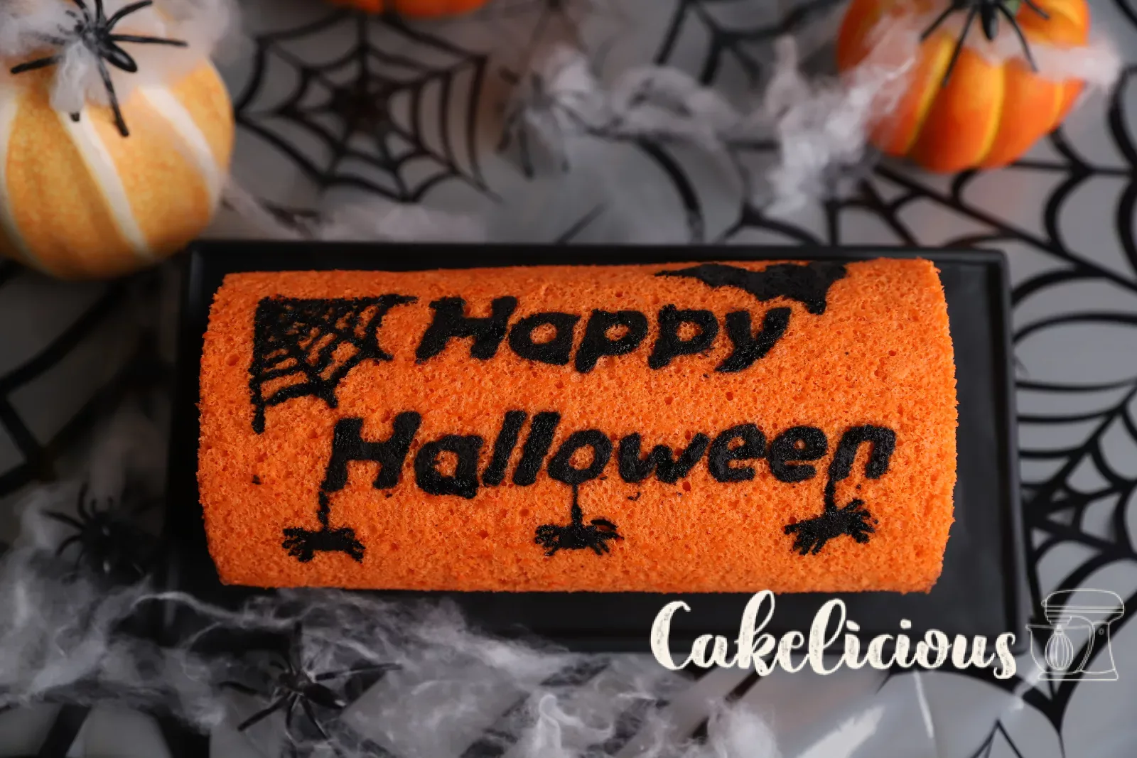 Halloween chocolate roulade with orange sponge and black bat motifs