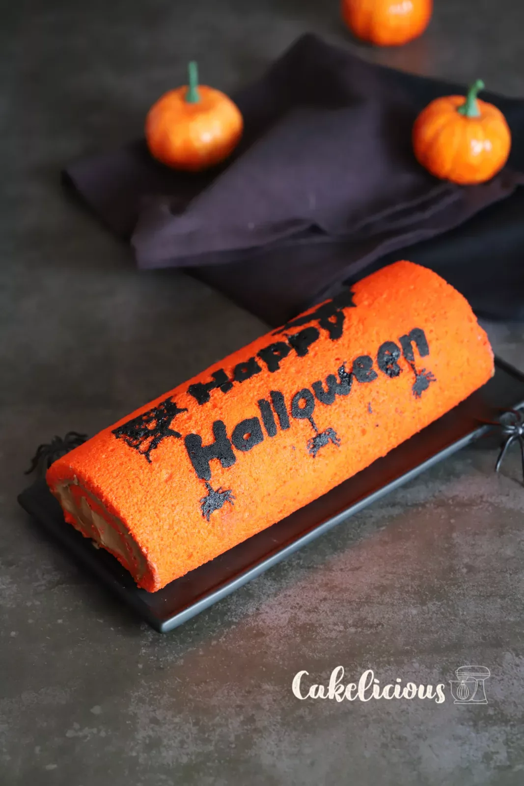 Halloween chocolate roulade with orange sponge and black bat motifs