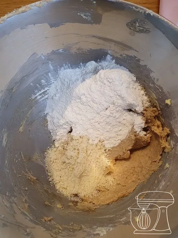 White flour and ground almonds being added to the mixture