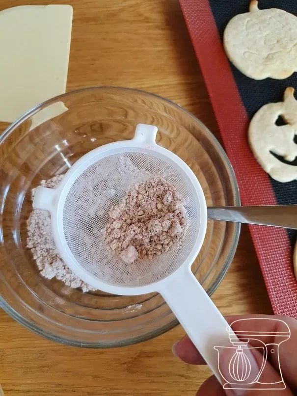 Cinnamon sugar being sprinkled over the cookies