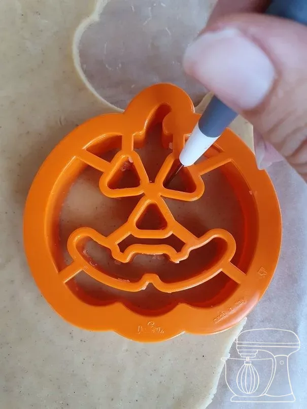 Pumpkin face being cut out with a cutter