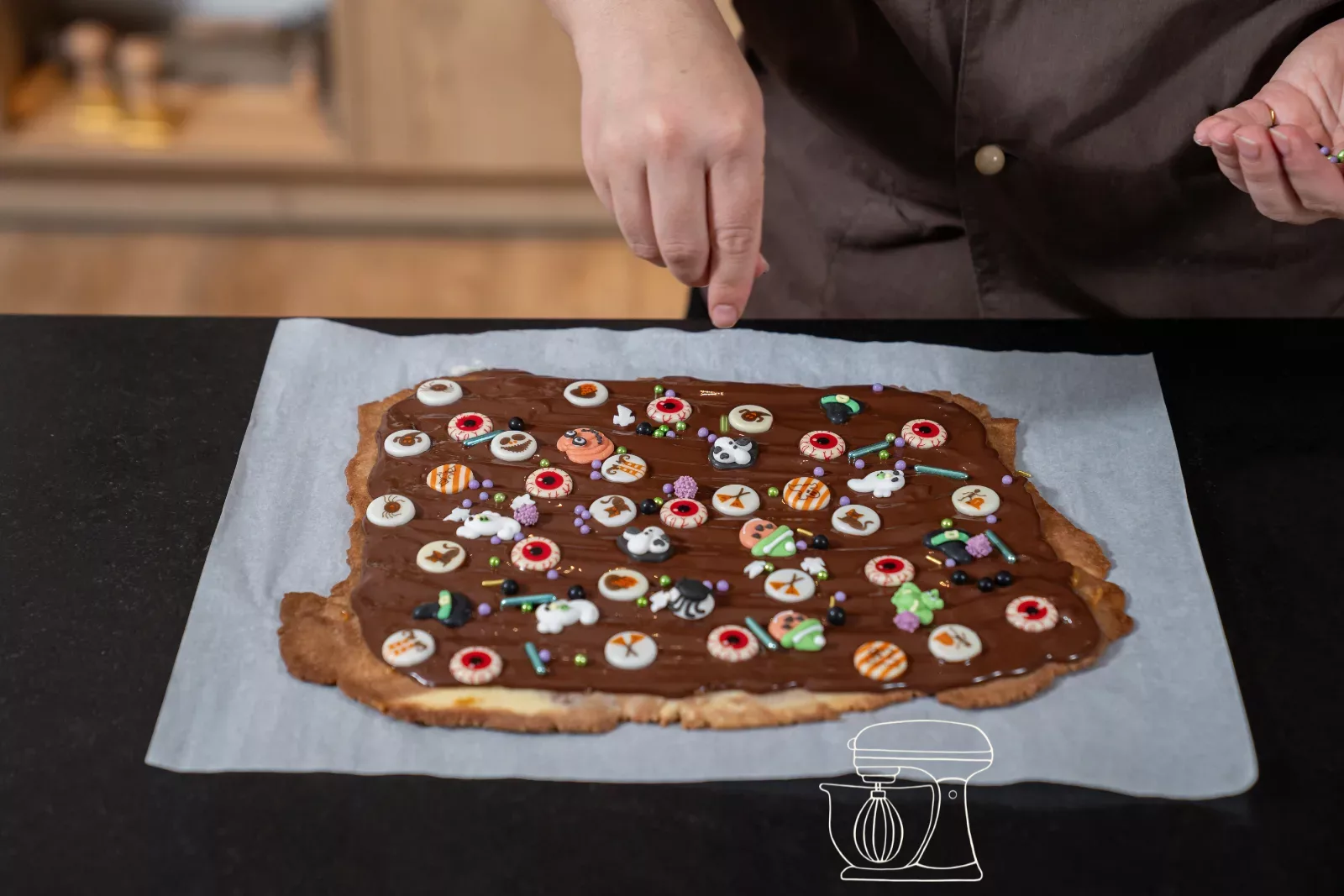 Halloween-Streusel und Zuckeraugen auf die Schokolade setzen