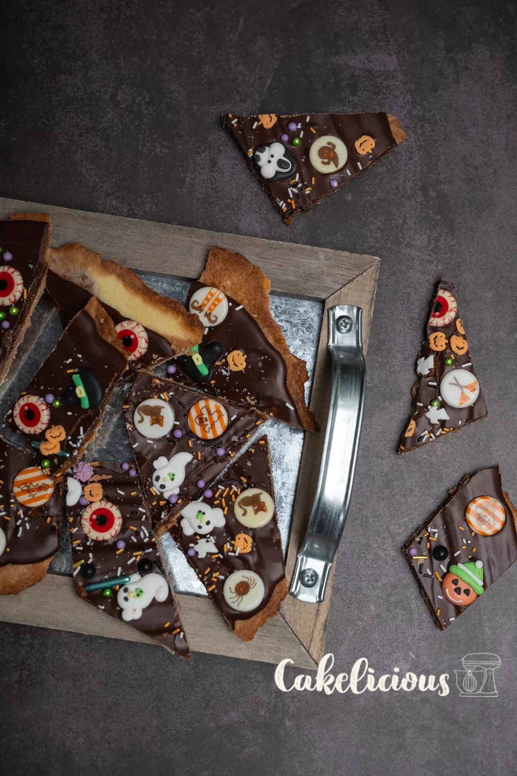 Halloween-Bark mit Zuckerdeko neben dunklen Schalen