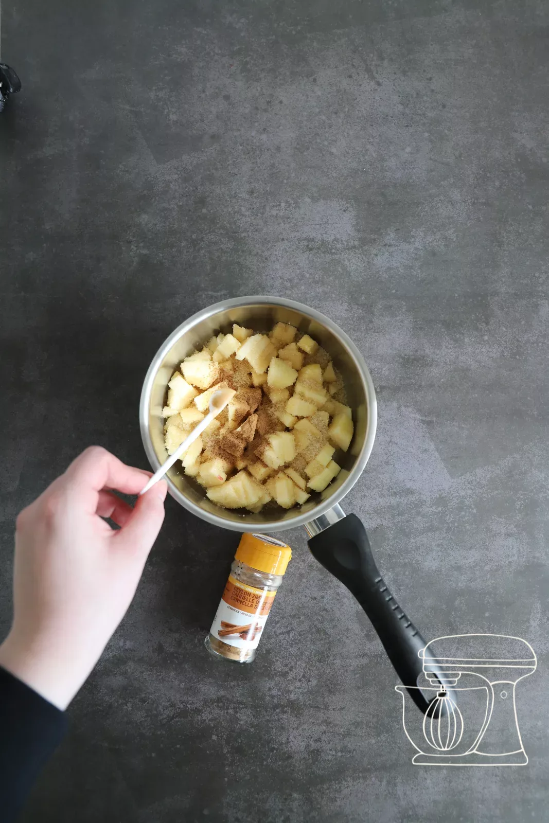 Cinnamon powder being added to the apples