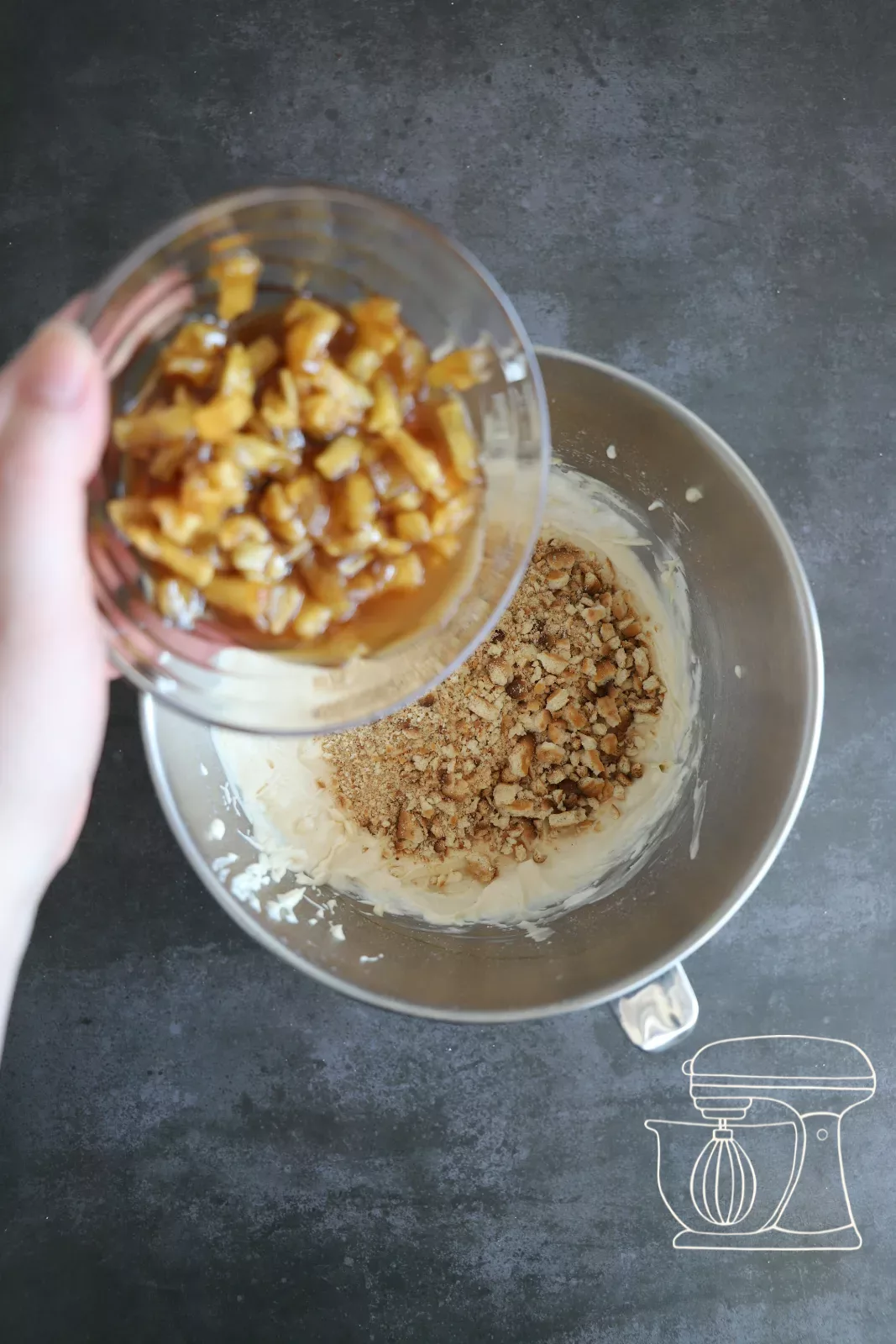 Crumbled biscuits being added to the cheesecake mixture