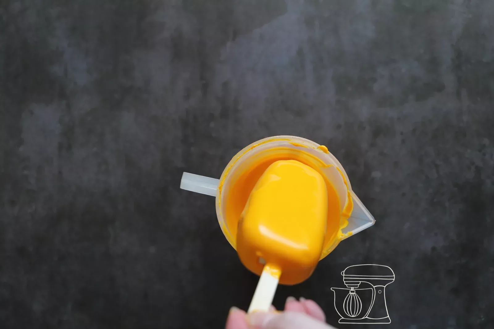 Excess icing being wiped off on the rim of the container