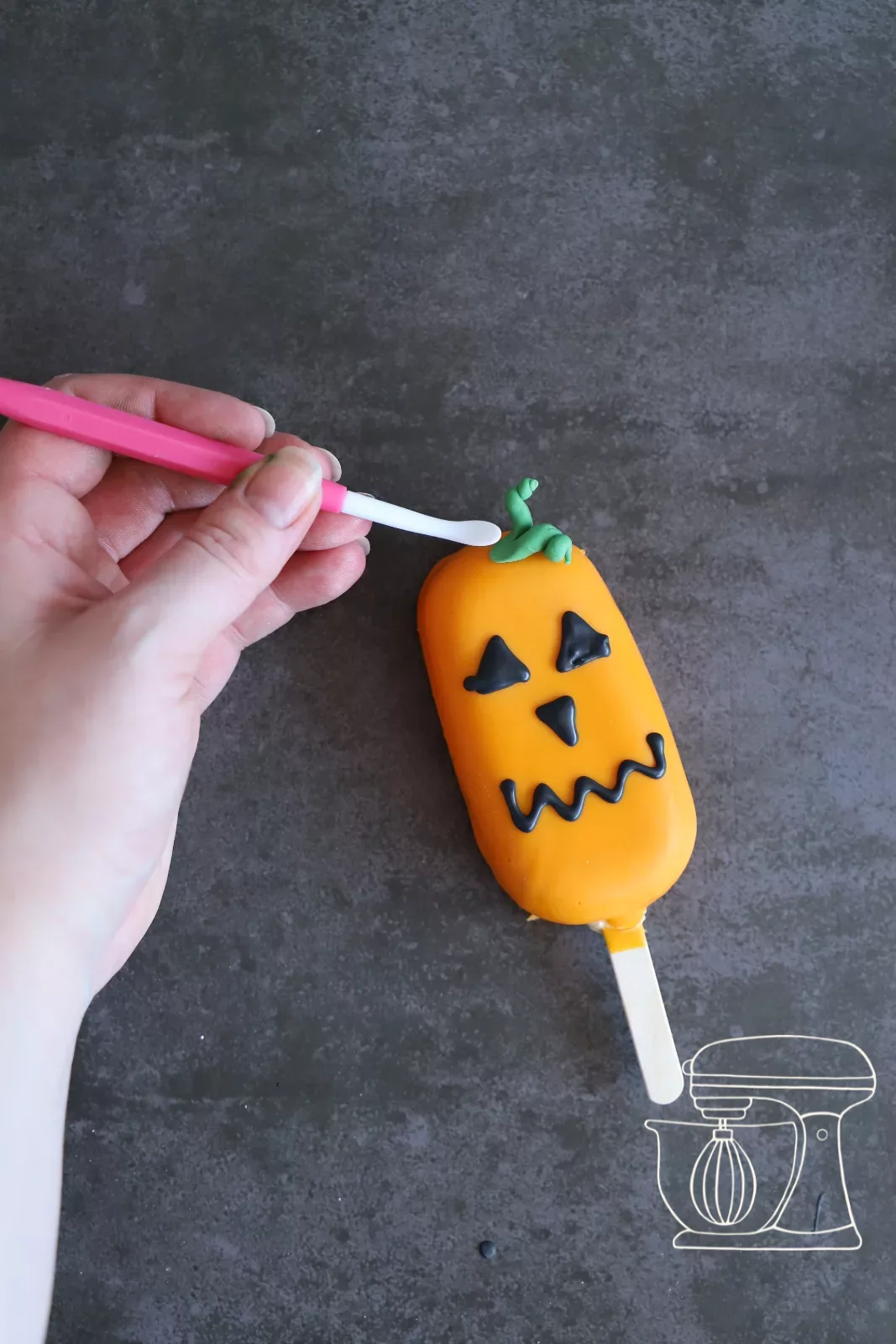 Finished pumpkin cakesicle with a fondant stem
