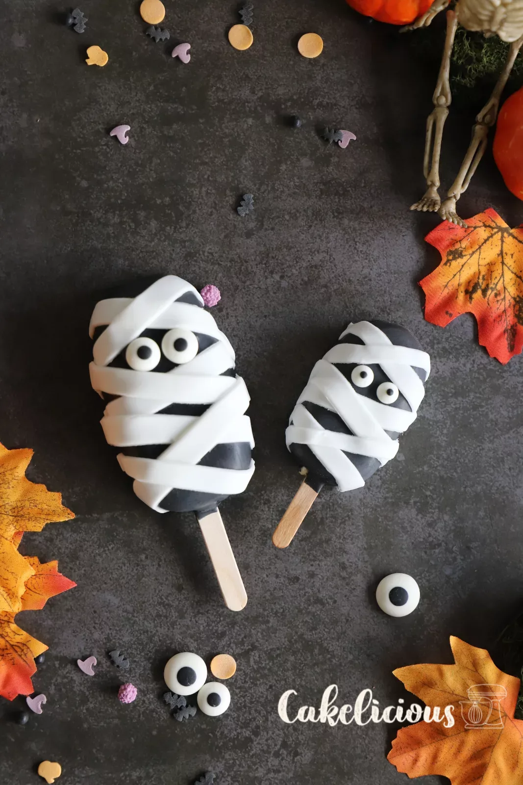 Halloween cakesicles decorated as a pumpkin, mummy, zombie and spider