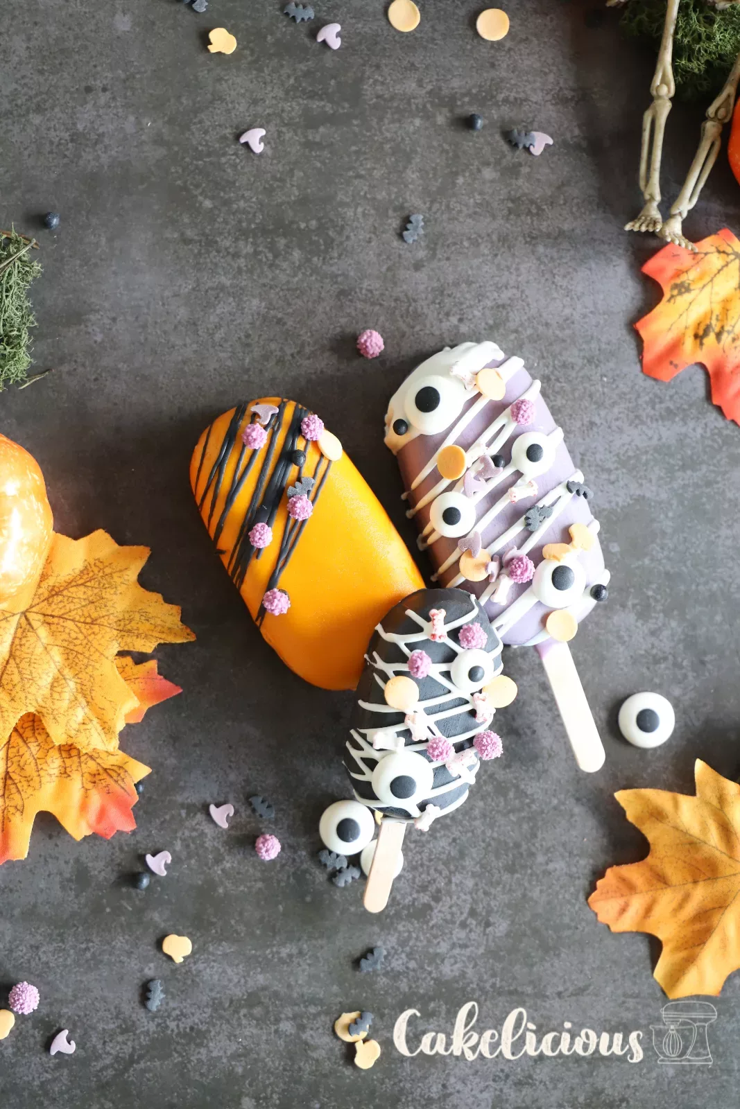 Halloween cakesicles decorated as a pumpkin, mummy, zombie and spider
