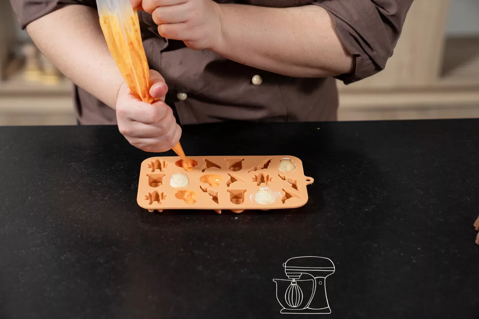 Orange Kuchenglasur in die Kürbismulden spritzen
