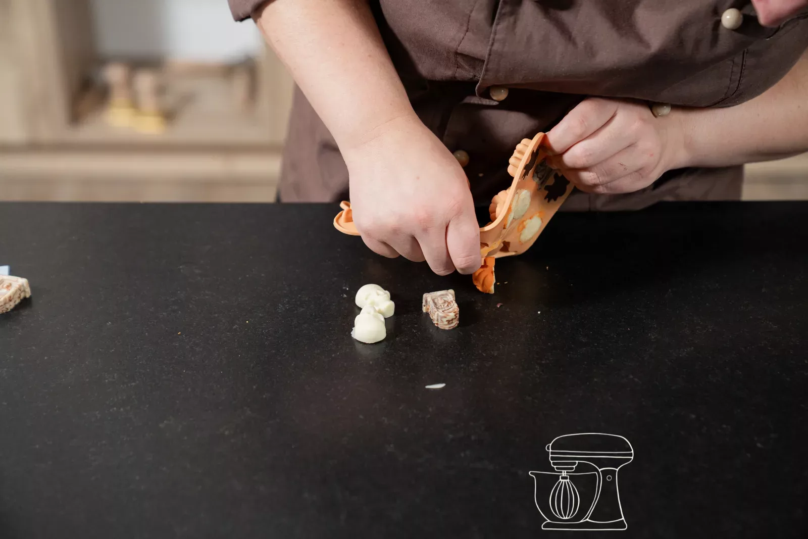 Fertige Guetzli mit Schoggi-Mantel aus der Form lösen