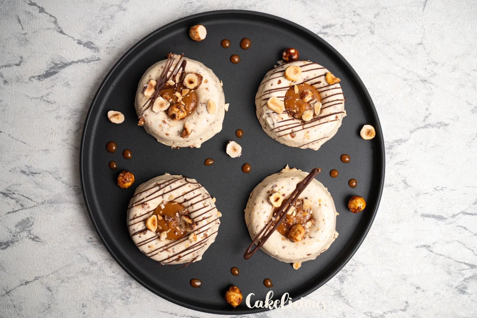 Hazelnut caramel parfaits from above, with copper spoons on a woven coaster